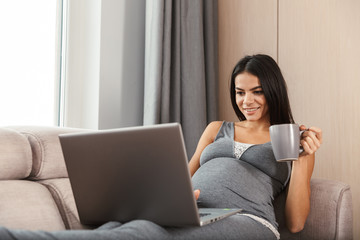 Beautiful young pregnant woman at home