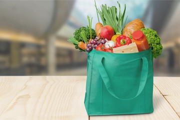 Full shopping  bag on table on wall background