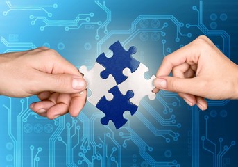 Hands of woman and man holding puzzles