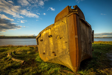 Obsolete small boats and barges were beached on the banks of the tidal River Severn in Gloucestershire, UK to protect the river banks from erosion