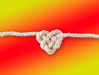 White rope in heart shape knot on background. Love concept.