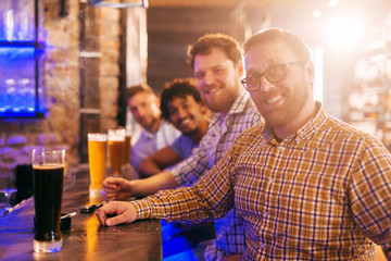 Four friends sitting at bar.