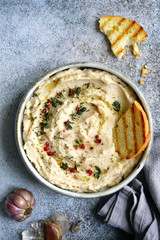 White bean hummus with baked garlic and dried herbs.Top view with copy space.