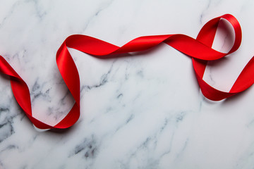 Red satin ribbon on a luxury marble background