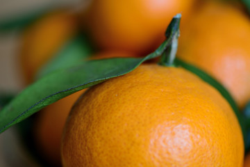 Ripe tangerines with leaves on a wooden background