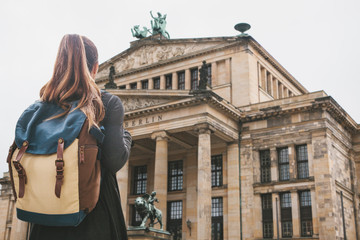 Tourist girl with a backpack or a student looks at the sights in Berlin in Germany.