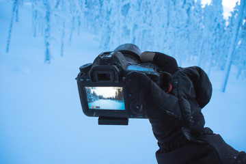 digital camera on tripod with glove into winter and snow