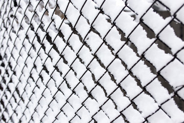 Snow and ice on a metal grid as a background
