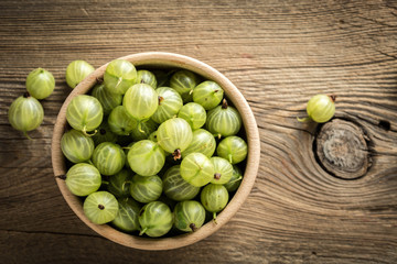 Fresh gooseberry in a wooden bowl.