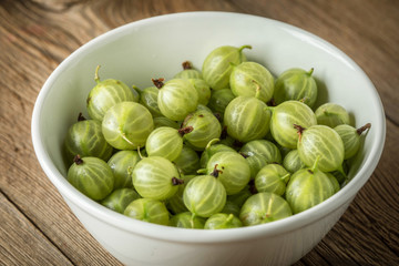 Fresh gooseberry in a white bowl.