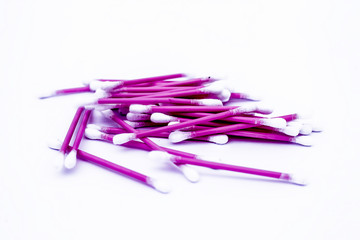 Pink colored cotton coated ear buds or Q-tips isolated on white.
