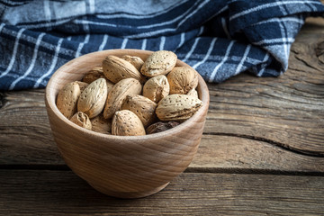 Almonds in-shell in wooden bowl.