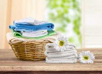 Laundry Basket with colorful towels on background