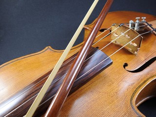 Close-up of a violin, a wooden string instrument, and a bow.