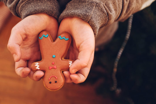 Homemade gingerbread man in child hands
