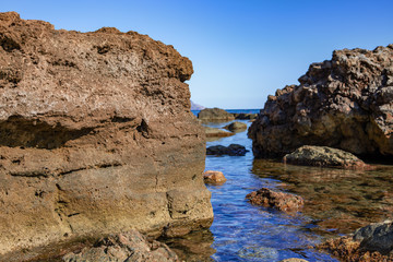 big boulders lying in water on seashore
