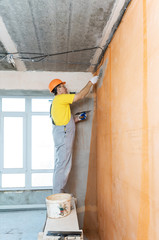 The construction worker putty a wall.