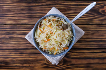 Bowl with sauerkraut and fork on table