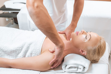Fototapeta na wymiar Male masseur doing shoulder massage to woman in spa salon