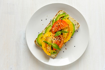 Avocado and tomato toast on plate with copy space