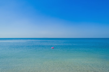 Fototapeta na wymiar Pink swim tube in sea and sky background
