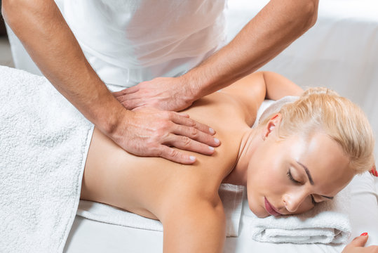 Male Masseur Doing Back Massage To Woman In Spa