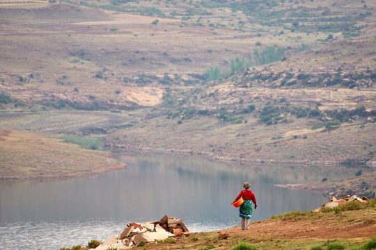 Mosotho Woman walks to get water from the Metolong Dam for her morning "basom" or bath in Lesotho.