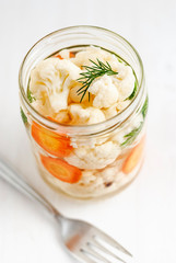 Jar with pickled cauliflower near fork