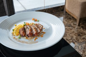 Roasted Duck Breast with orange sauce and Potato on white plate