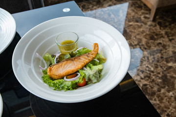 Grilled salmon on top of fresh salad, Concept of healthy food. Salad with green leaves and boiled salmon. Food photography. Fresh foods