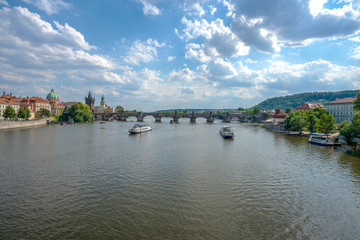 Fototapeta premium Beautiful summer day, Vltava river, ships and old city center, Prague, Czech Republic. Charles Bridge