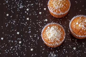 New year and Christmas concept banner with homemade coconut muffin dark background. Top view. Selective focus.