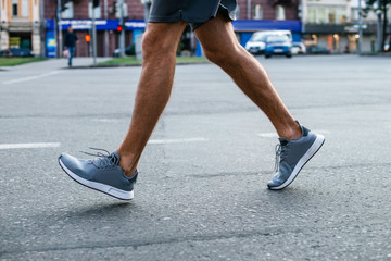 Morning strength. Part of young man in sportswear jogging on the street