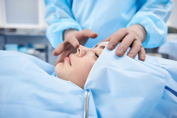 Doctor making rhinoplasty to lady. Surgeon palpating female patient nose - obrazy, fototapety, plakaty