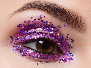 Close eye with colorful eyeshadow. Macro shot of opened female eye. Woman with evening beauty...