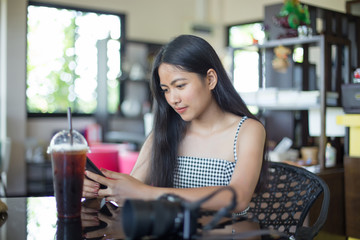 asian woman enjoy with the cellphone in the cafe'
