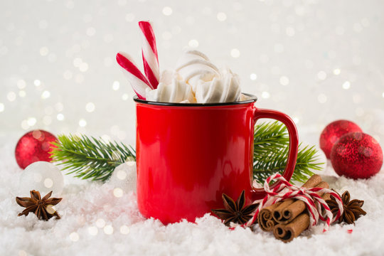 Cozy winter composition with a red cup of hot chocolate with marshmallows  on a light festive background.