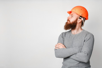 Young brutal construction worker in hard hat on a white background