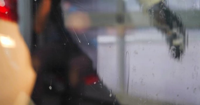 The professional washer by the windows of the car wash (in the car-care center) washes the window from a Karcher, and accessories for washing windows, is shown very close. Concept of: Detergents, Clea