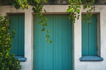 Obraz premium Closed wooden shutters on the windows and doors of the Mediterranean authentic home