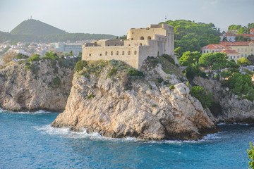 Fototapeta na wymiar Scenic view of Fort Lovrijenac in ancient touristic town Dubrovnik in Croatia. Beautiful aerial view of fortress on cliff in sunset light in old european resort on Adriatic sea.