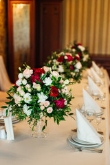 Beautiful bouquets of roses and peonies on a serving table for a
