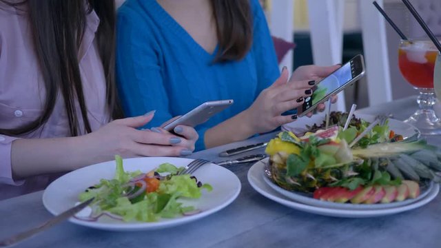 bloggers girlfriends take photo of beautiful meal on smartphone during healthy lunch during diet for weight loss in restaurant close-up