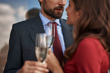 Concept of happy romantic date. Close up portrait of beloved couple with champagne glasses looking with love to each other