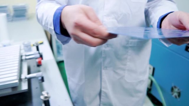the worker takes the motherboard and transfers it to the conveyor line for further work. Printed circuit boards production factory. Technological process. Microchip production factory