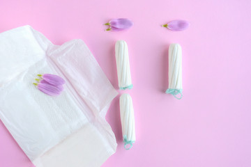 Obraz na płótnie Canvas Kiev, Ukraine - 11.29.2018. Tampons with selective focus and petals on pink background. Woman hygiene for period days. Ginecology pads for menstrual mothly cycle. Protective care for woman health.