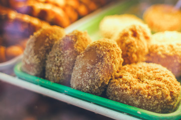 Trays of fresh donuts lined up in a bake shop case