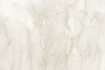 Gold alcohol ink wash texture on clean paper background. Liquid paint flow. Transparent ethereal effect.