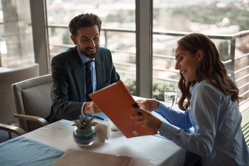 Business lunch in friendly atmosphere. Portrait of young smiling male and female colleagues...
