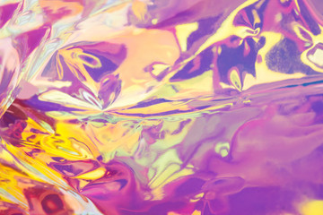 Bright holographic foil background. Multicolored and pastel trendy backdrop.